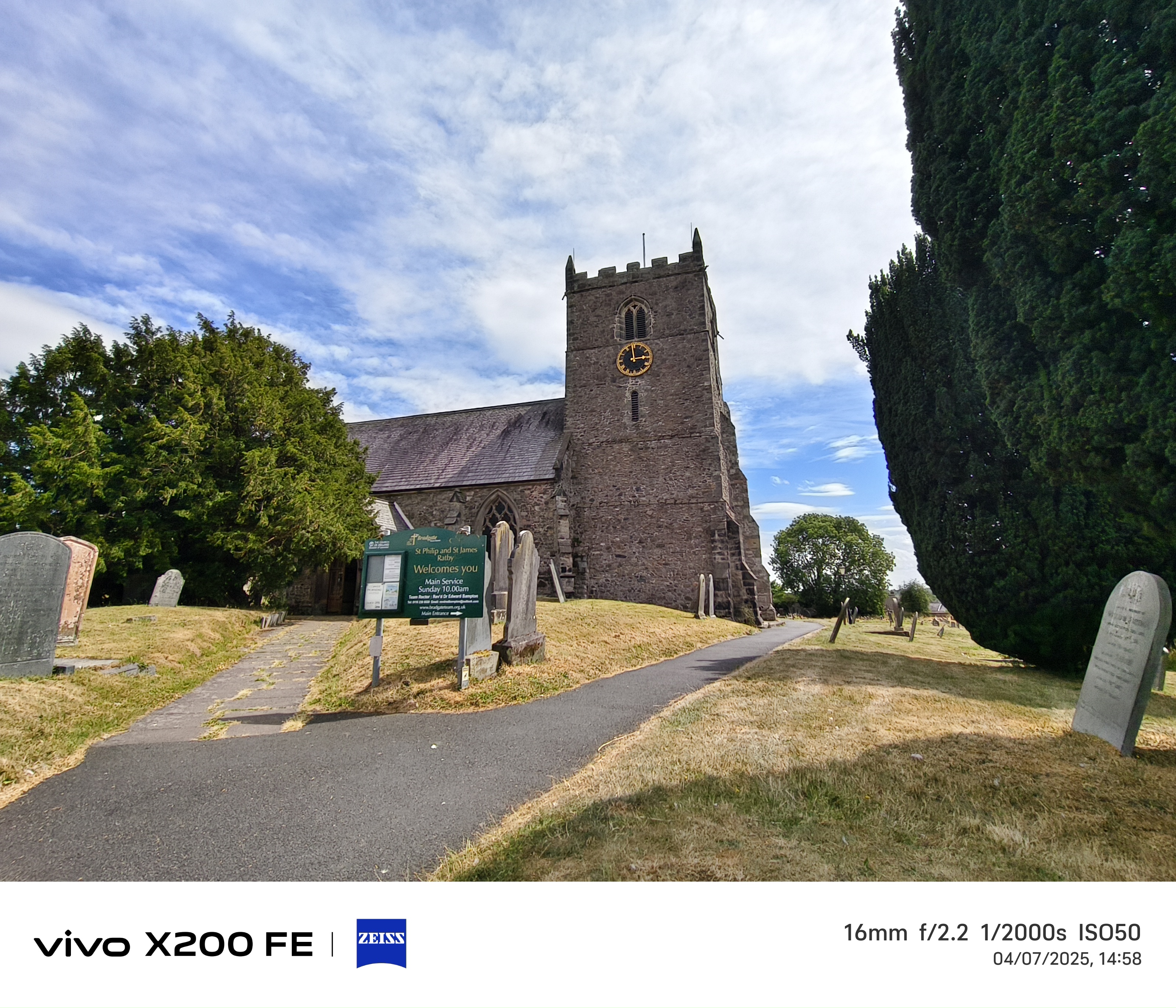 Church in front of a blue sky surrounded by a graveyard