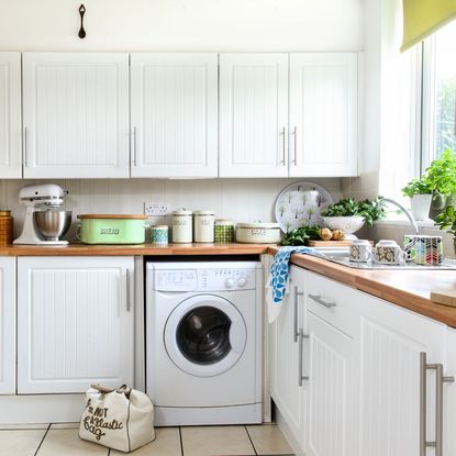 kitchen room with white wooden flooring and white cabinets