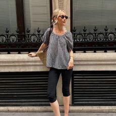 Influencer @chloekathbutler wears a short sleeve gingham blouse with capri pants and suede mule heels.