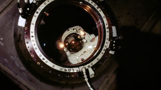 Astronaut Robert L. Curbeam photographed through a hatch while on a spacewalk.