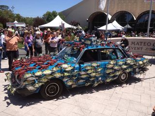 a car covered in plastic fish at maker faire on may 18, 2013.