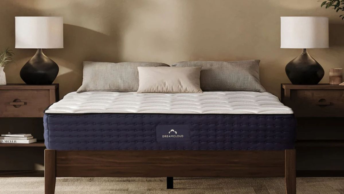 The DreamCloud Hybrid mattress on a wooden bedrame in a spacious bedroom