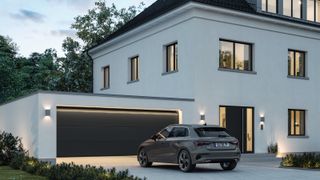 white modern rendered house with large grey garage door, with grey car parked in front