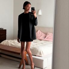 Woman taking a mirror selfie wearing a black outfit