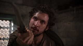 Mat holds the ruby-hilted dagger up to someone off-camera in The Wheel of Time season 1