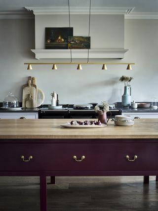 grey kitchen with purple painted freestanding kitchen island, pendant lighting, AGA, artwork