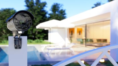 A security camera outside a house and pointed off the property.
