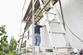 a tradesperson working on the exterior of a house