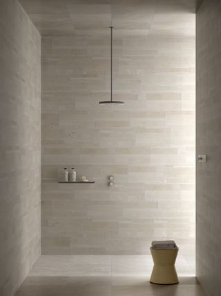A beige shower room with natural stone tiles