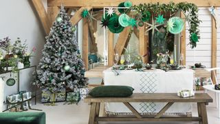 Barn-style living space with exposed beams with dining table and christmas tree theme to show a natural woodland style
