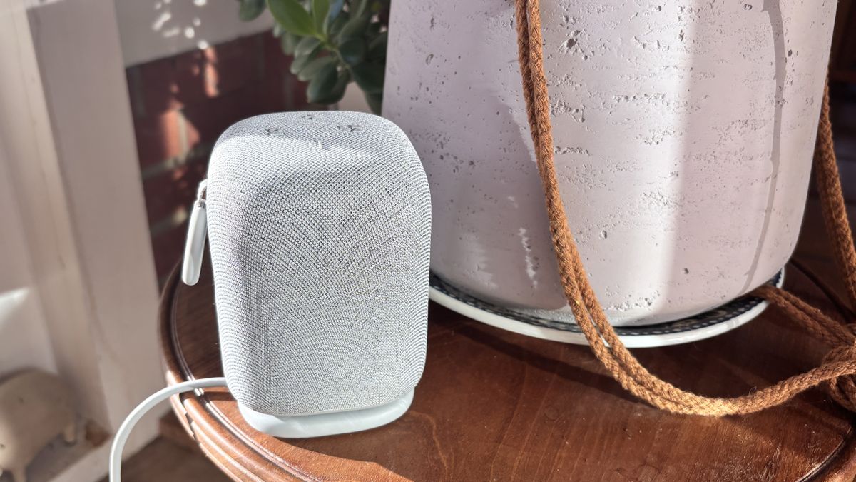 Sony LinkBuds Speaker on its charging base on wooden table