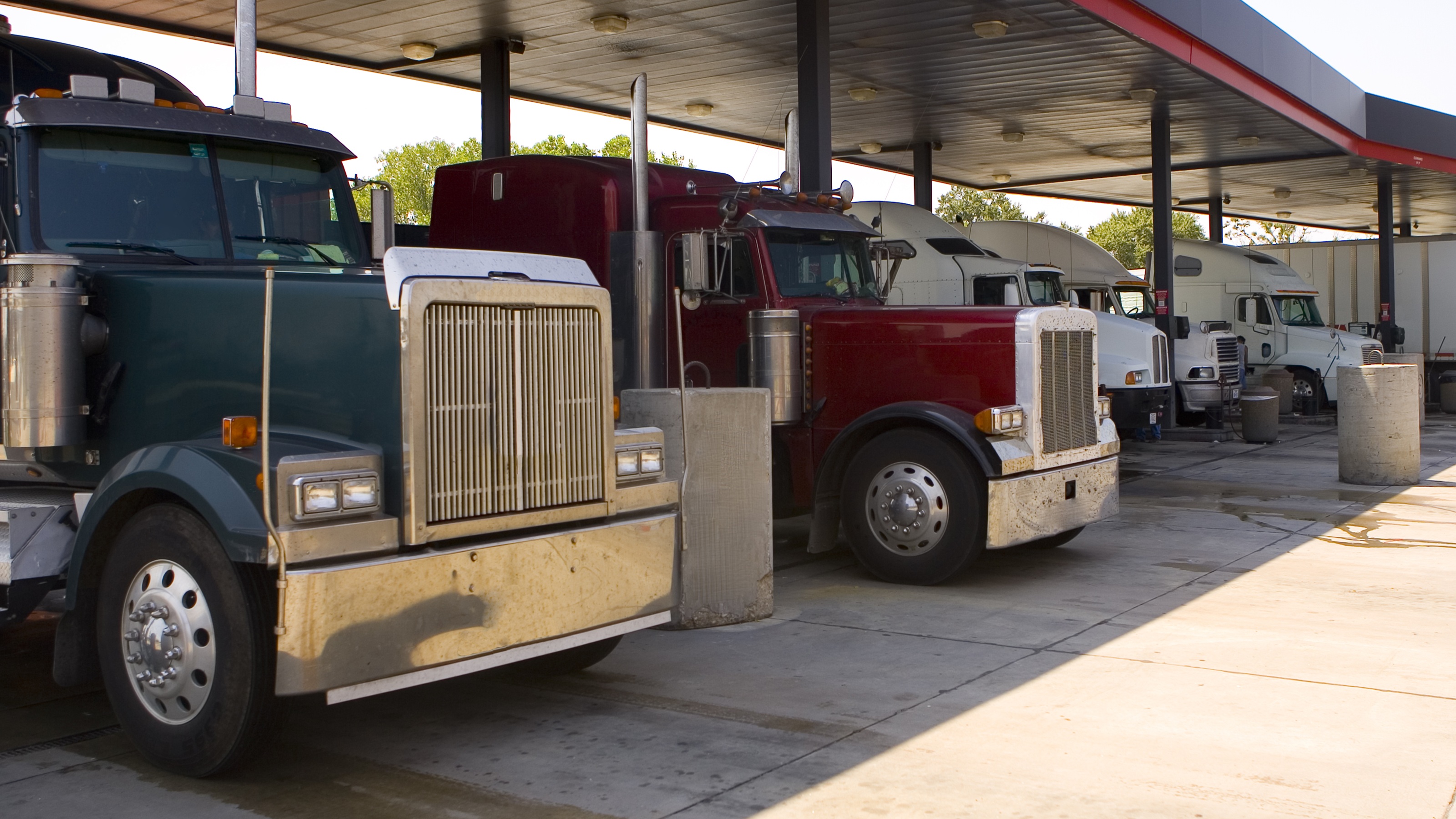 Semis lined up at a truck stop.