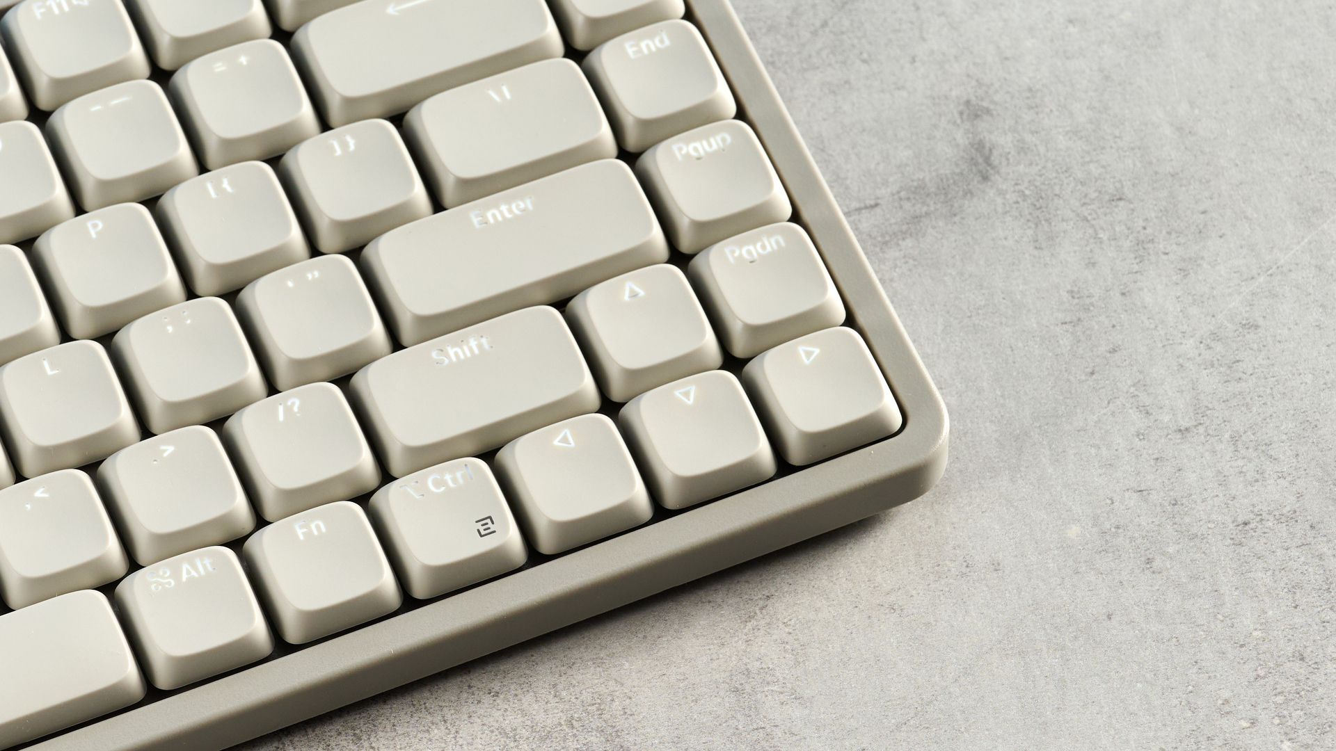 The Lofree Flow Lite84 on a stone surface with its keycaps lit by a backlight