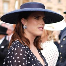 Princess Eugenie wearing a navy dress and hat