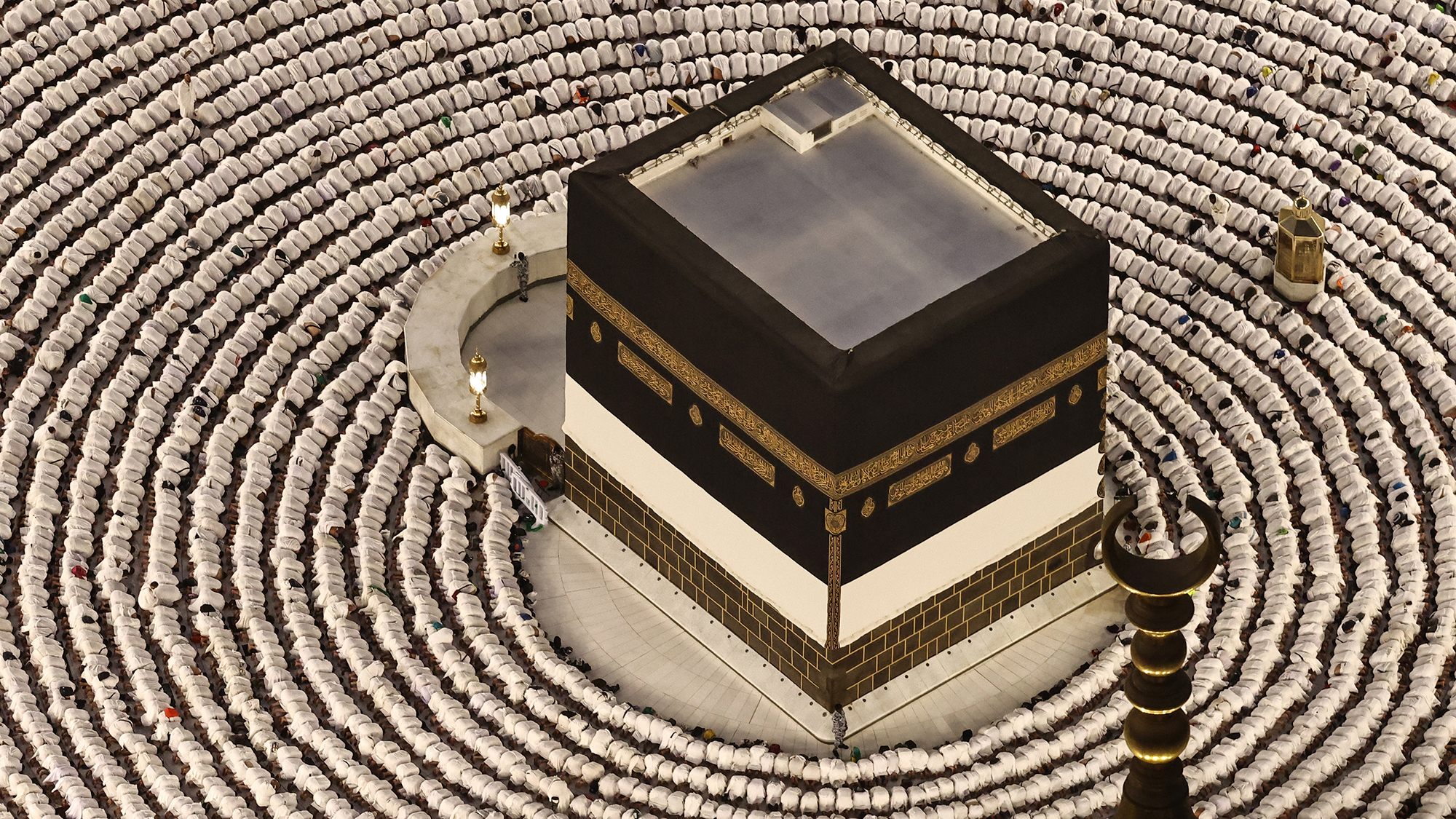 Muslim devotees perform the evening prayer around the Kaaba, Islam's holiest shrine, at the Grand Mosque complex in Mecca, Saudi Arabia