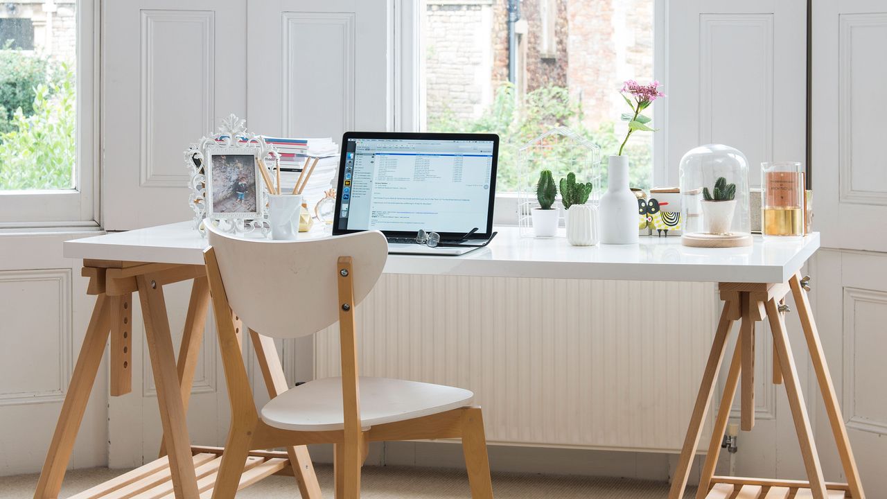 white and warm wood desk with laptop and chair facing large window