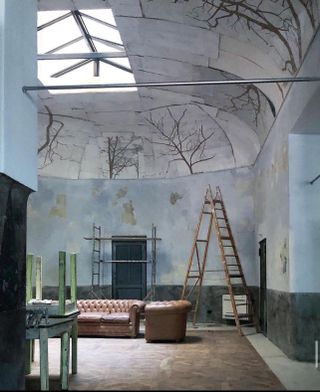 Interior under restoration, with forms of trees frescoed on ceiling