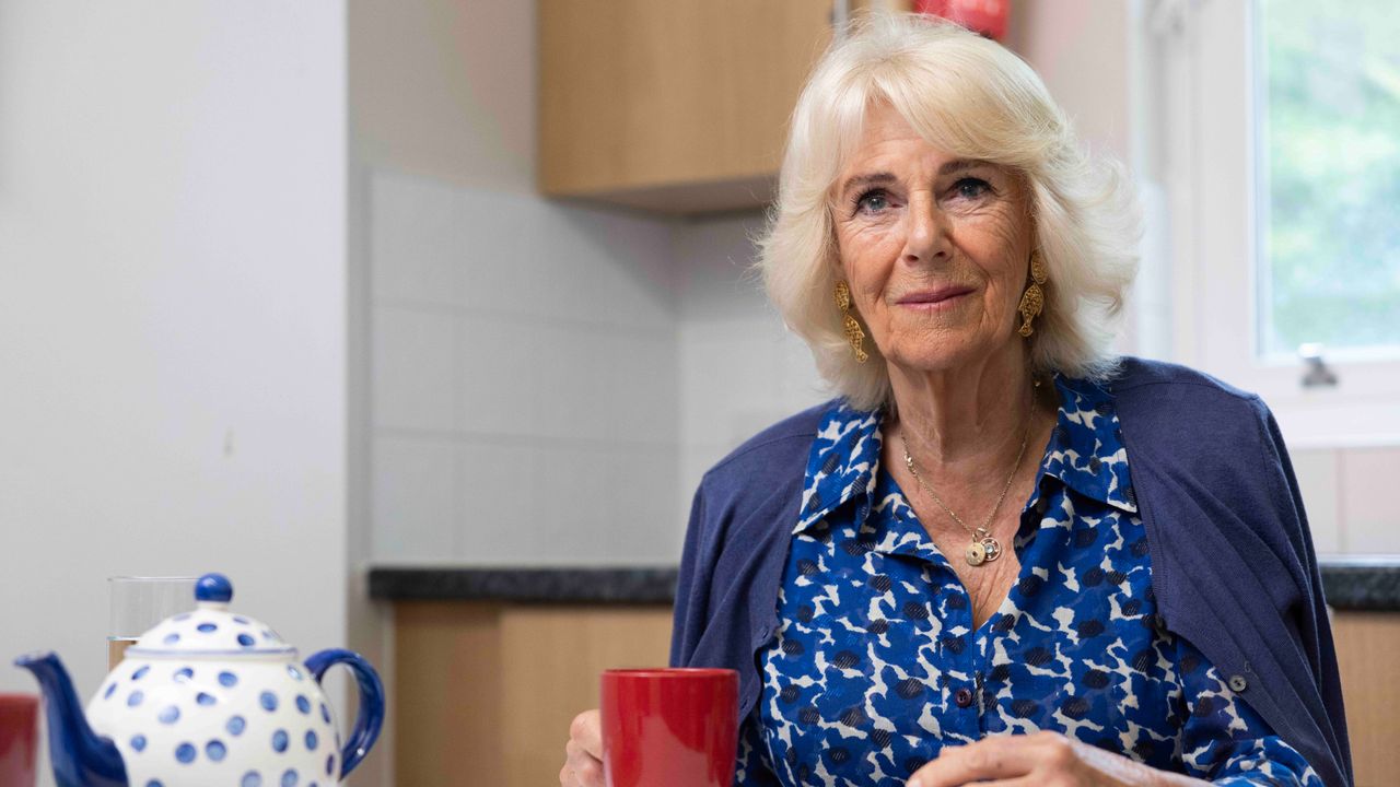 Queen Camilla sits holding a cup of tea at a table in ITV&#039;s Her Majesty The Queen: Behind Closed Doors