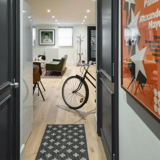 hallway with black doors and a bike in the living room