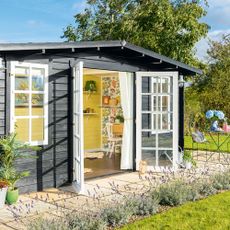 Black summerhouse with yellow paint