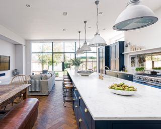 Kitchen with long kitchen island with lighting over the top