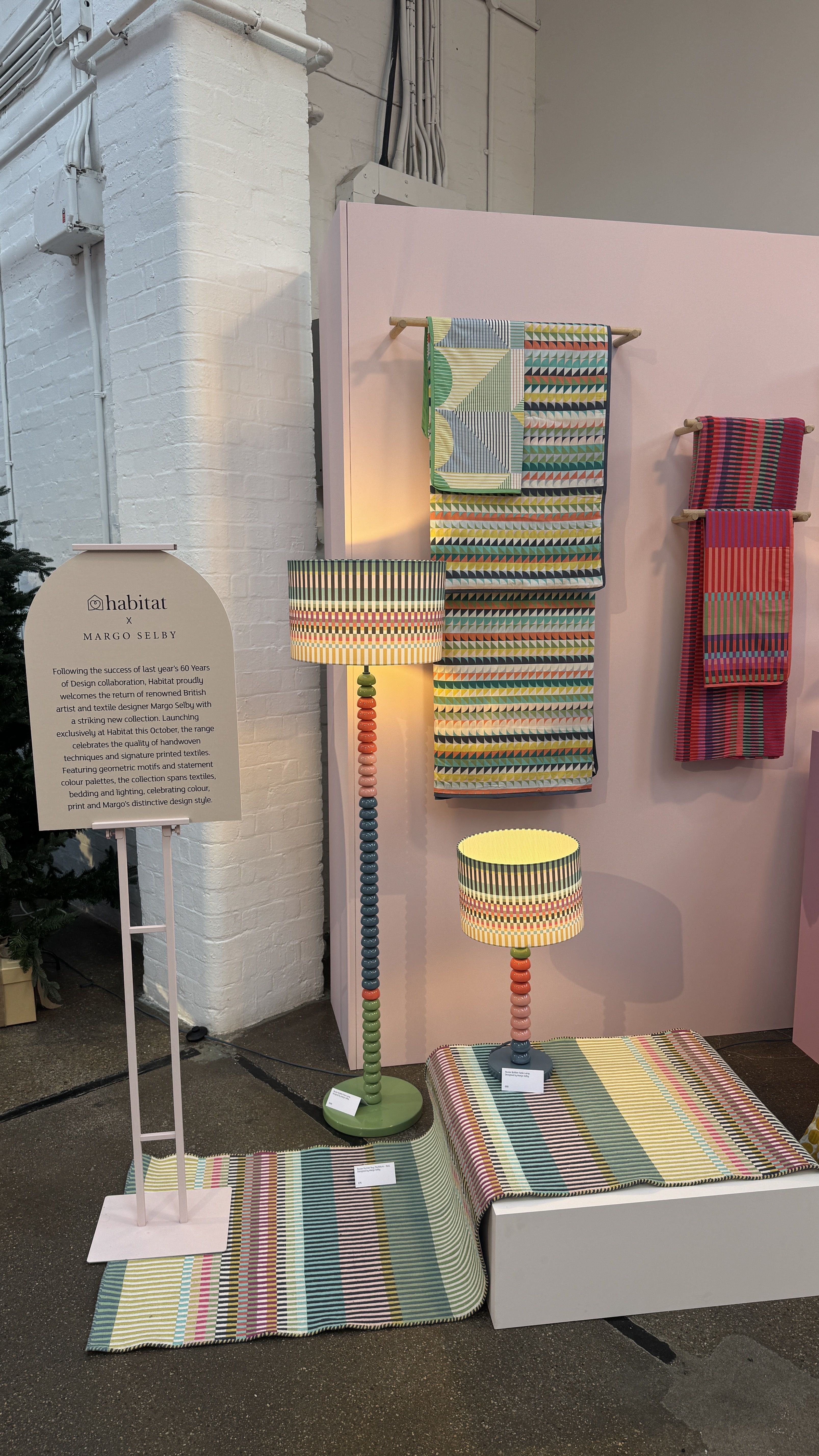 colorful bobbin lamps on a colorful rug with colorful towels hung in the background