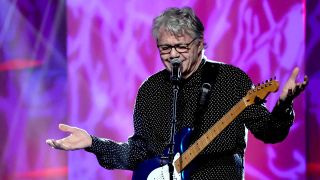 Steve Miller onstage making a "shrugging" gesture