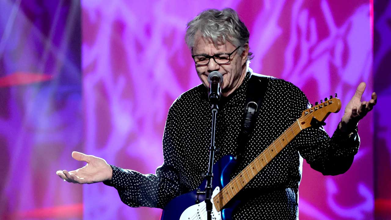 Steve Miller onstage making a "shrugging" gesture