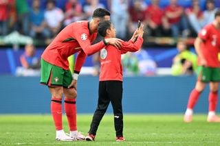 Cristiano Ronaldo poses for a selfie with a young fan ar Euro 2024