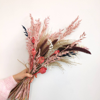bouquet of mixed dried flowers in woman hand