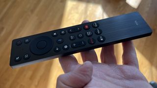 TCL QM6K remote control held in hand