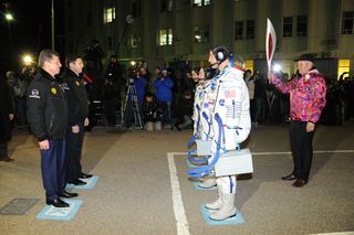 The Olympic torch and crew of Expedition 38 walk out to the pad to launch toward the International Space Station on Nov. 7 local time at Baikonur Cosmodrome, Kazakhstan.