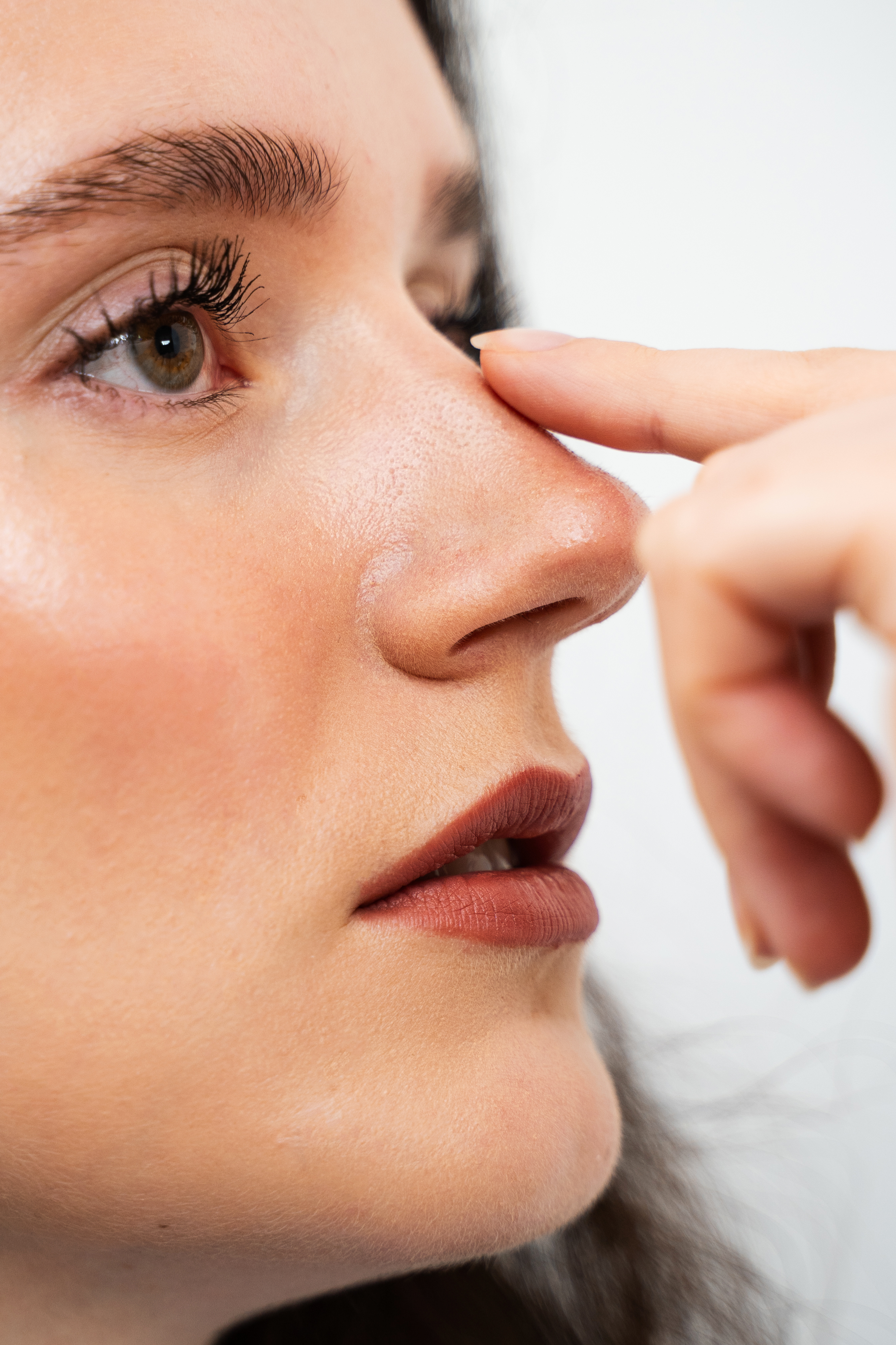 a woman in profile wearing red lipstick with a straight nose