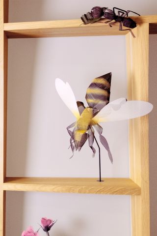 Model of bee on wooden shelf
