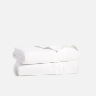 Two white fluffy folded towels in a stack 