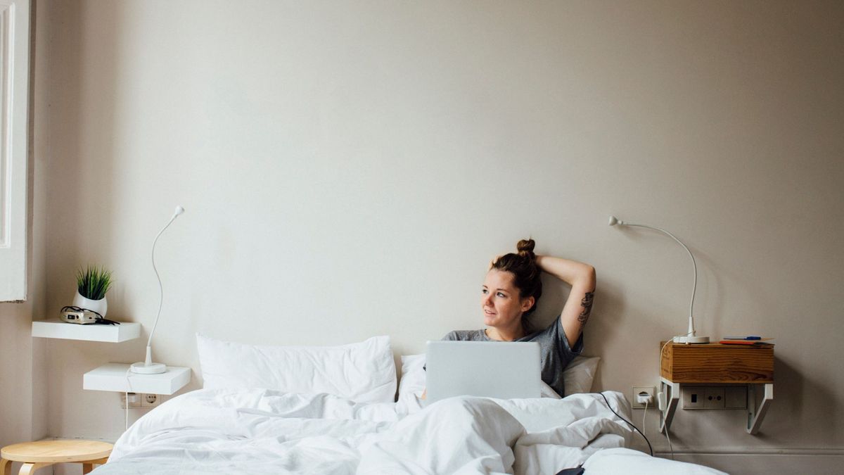 A woman working from her laptop in bed