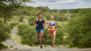 Two athletes running on a country road