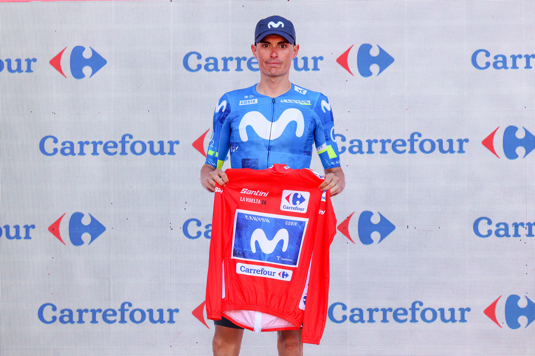Enric Mas holds the red jersey on the podium after stage 8 of the Vuelta a Espa&ntilde;a