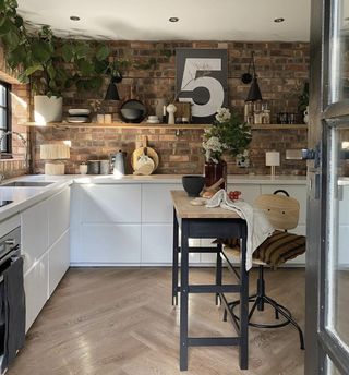 White IKEA kitchen with exposed brick walls
