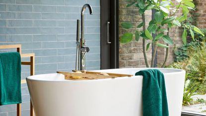 Bathroom with blue subway tiles and green towels