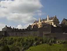 The exterior of the great hall at Stirling Castle. It has been limewashed and its parapets restored with heraldic beasts, battlements and turrets.