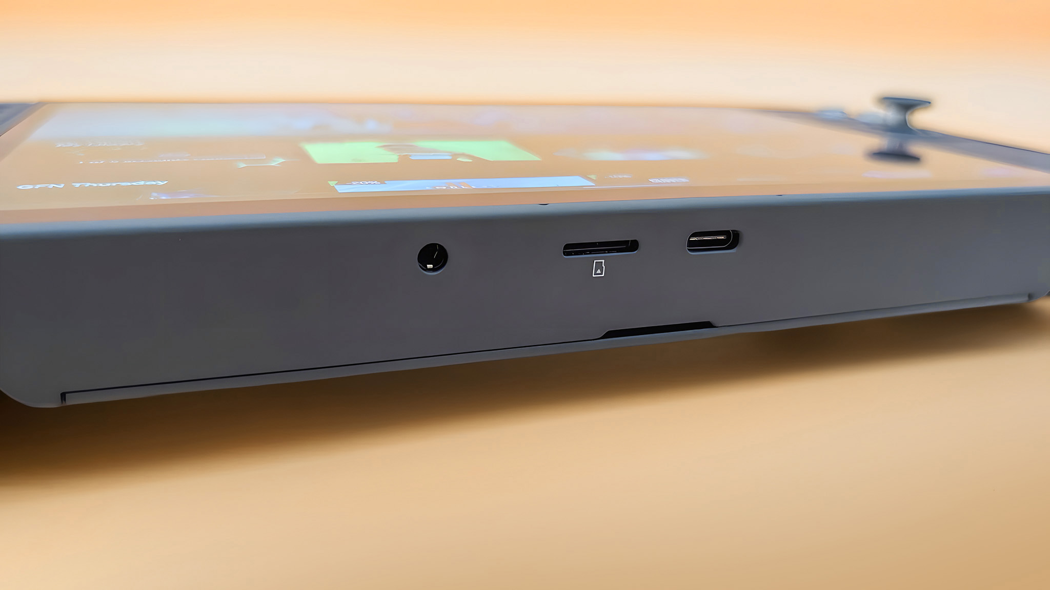 A closeup of the Lenovo Legion Go 2's headphone jack, microSD card reader, and USB4 port on the bottom of the handheld.