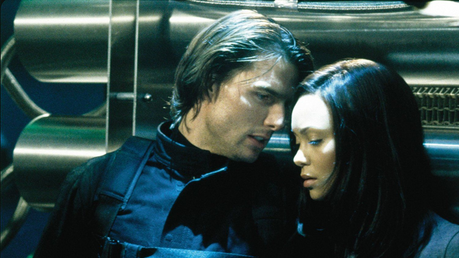 Mission Impossible movies in order: Tom Cruise as Ethan Hunt whispering to a woman.