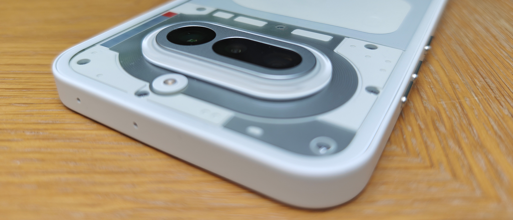 A white smartphone on a wooden desk