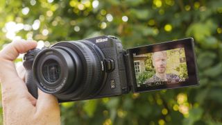 A hand holding the ikon Z30 vlogging camera