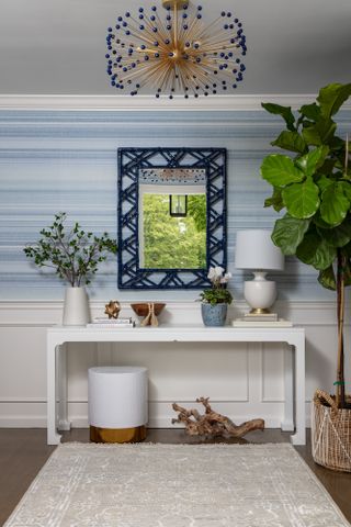 An entryway with a mirror above the console