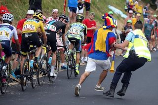 A gendarme removes an over zealous spectator from the road