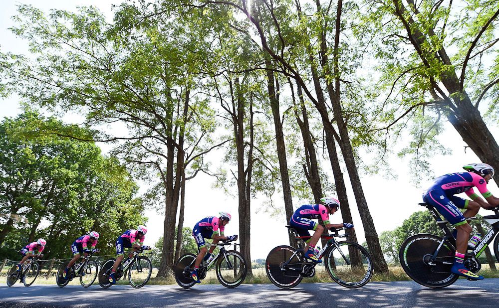 Lampre-Merida ride under a canopy of trees during the Dauphine TTT.