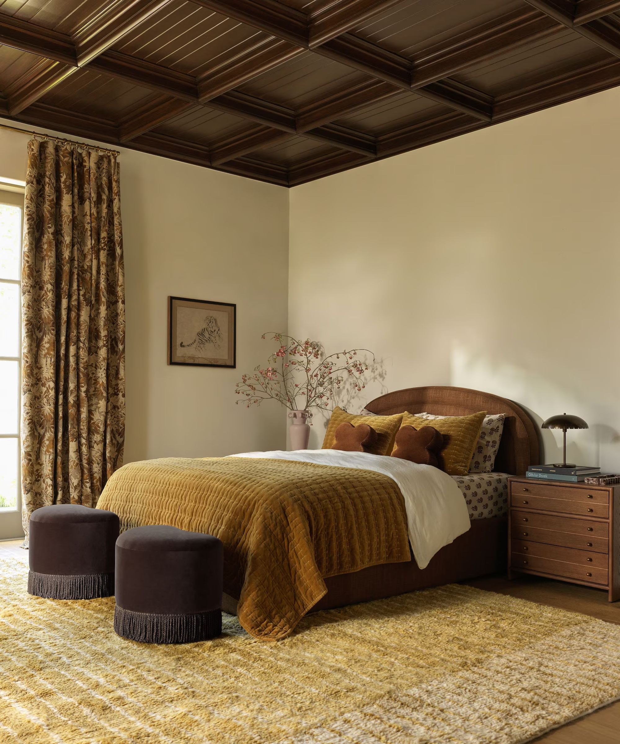 lulu and georgia fall collection cozy bedroom with ochre tones, chocolate brown ottomans, and a large rug