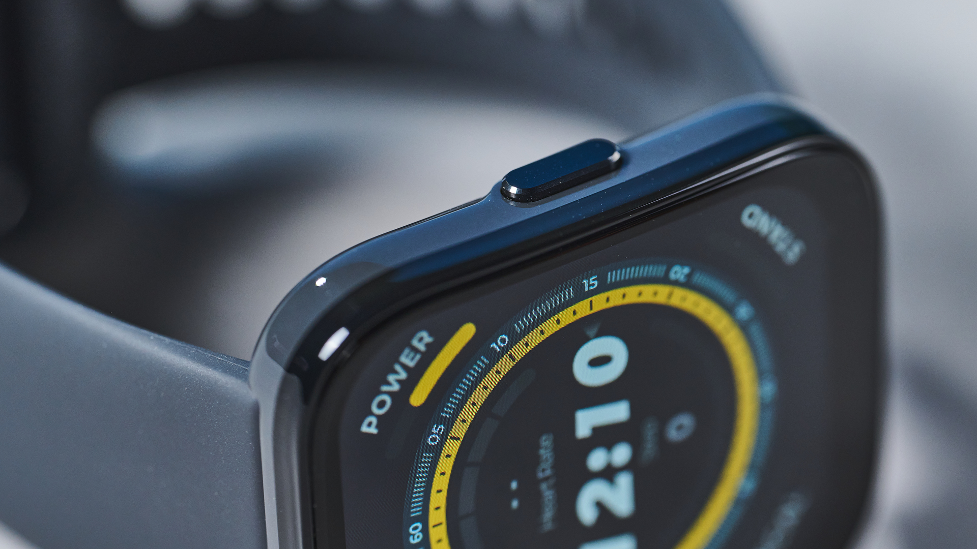 a black fitness tracker Amazfit Bip 5 showing the default yellow and blue toned watch face and fitness capabilities